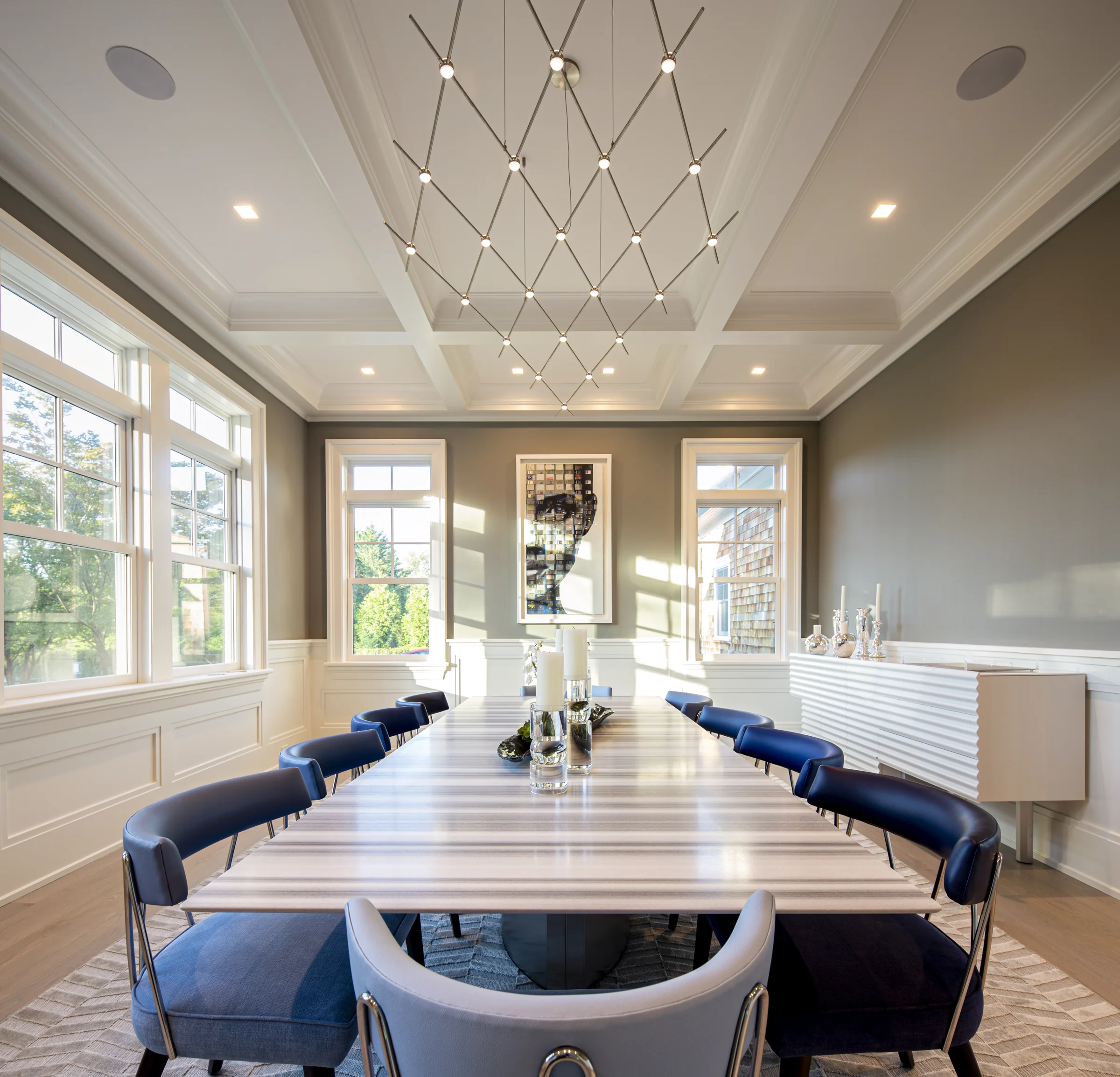 The dining room head-on, the sculptural fixture lit for the evening