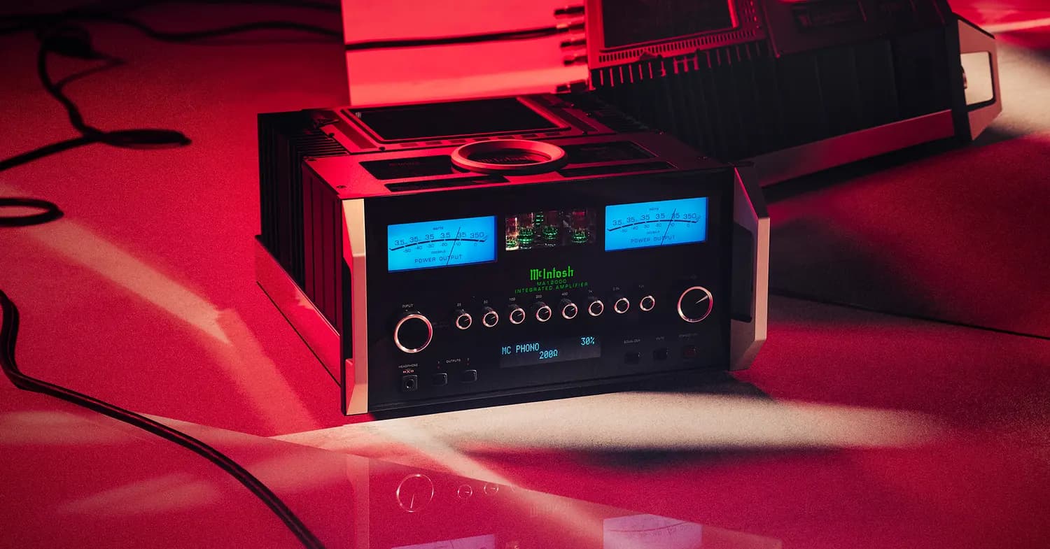 A McIntosh amplifier in a dark room, its blue meters glowing