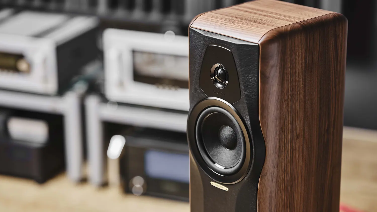 A Sonus Faber loudspeaker at home, warm wood against a wall of amplification