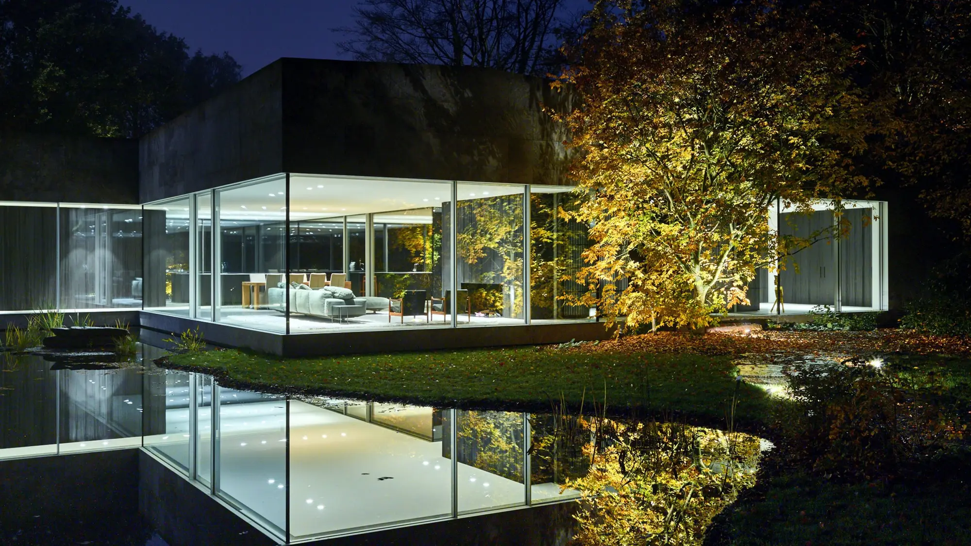 A modern glass house at dusk, its sound built invisibly into the architecture