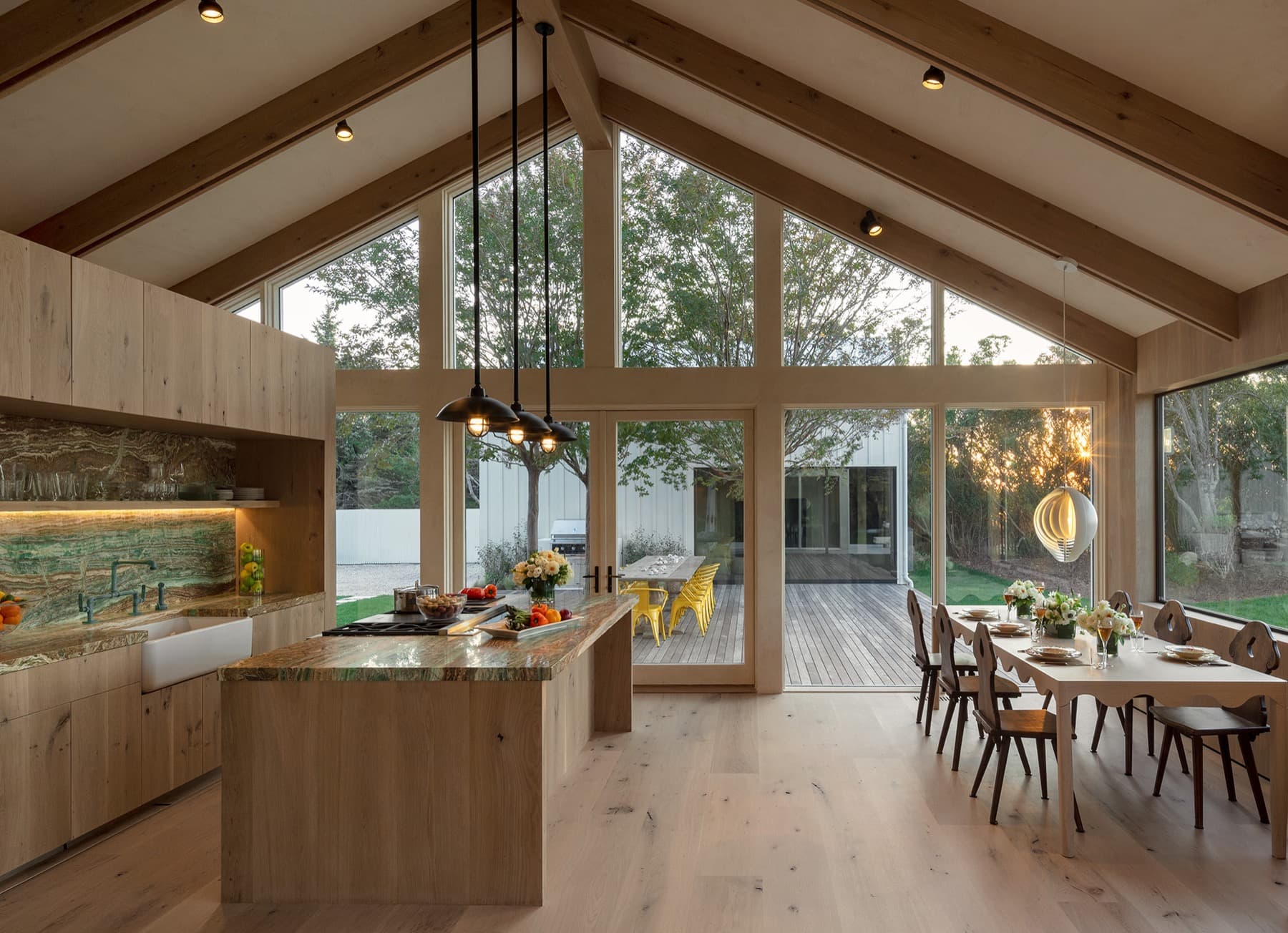 A warm white-oak Hamptons kitchen where Lutron light and shade are coordinated at golden hour