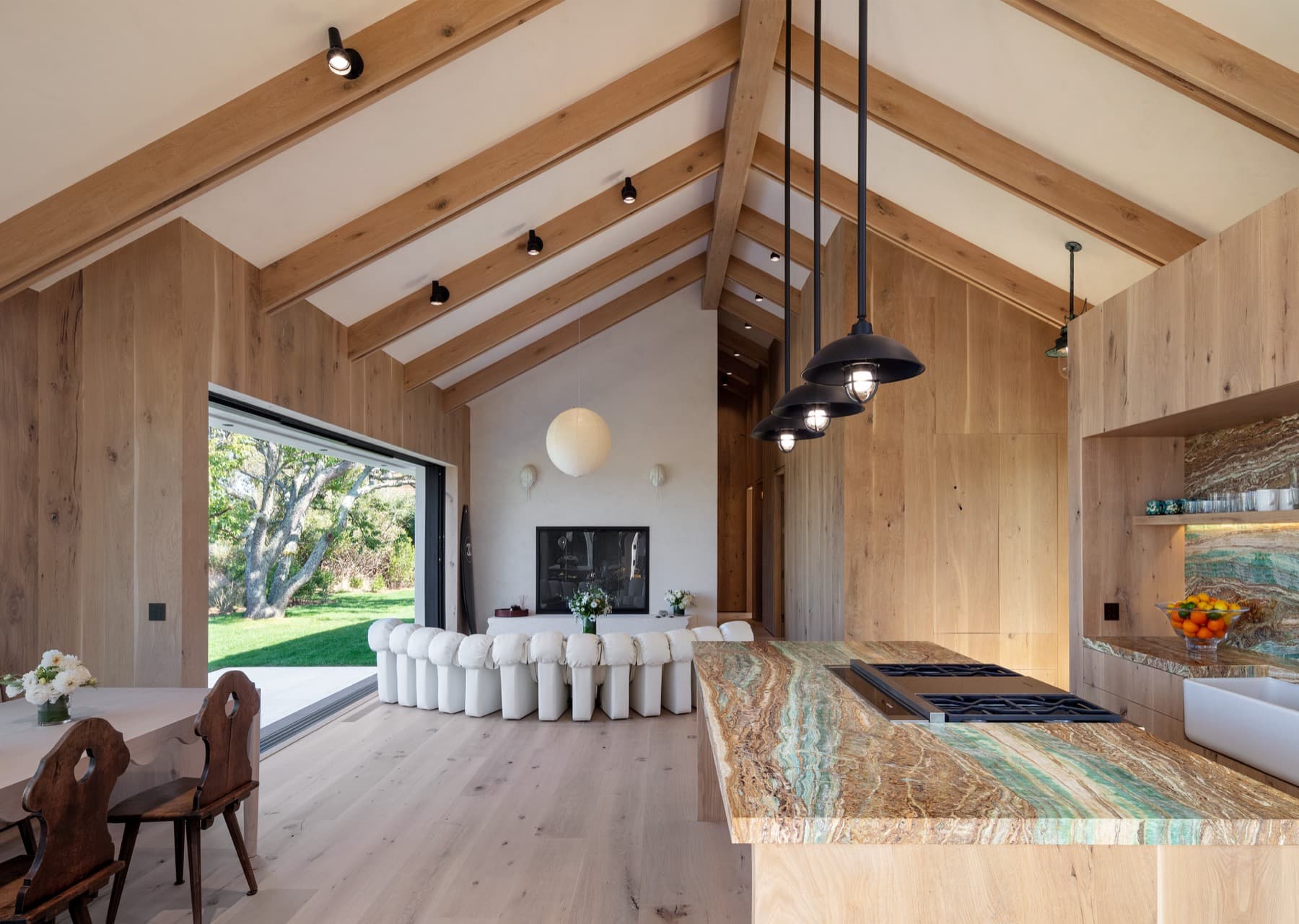 A vaulted white-oak great room in bright, natural midday light from Lutron Ketra