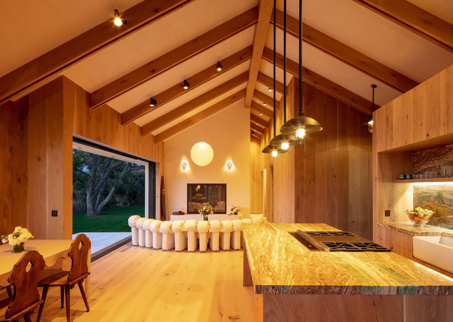 The same great room in the evening, a low, warm candlelight glow