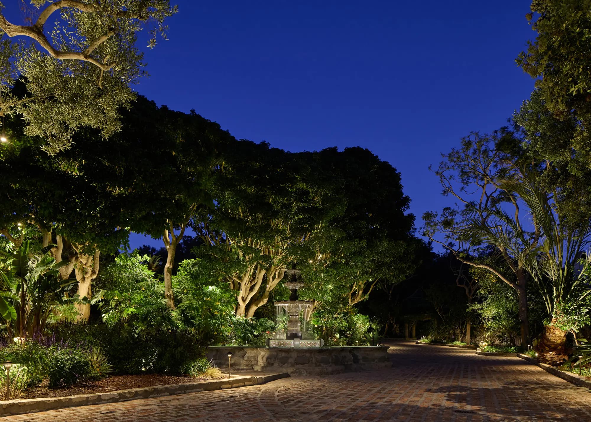 A luxury garden at dusk, lit with concealed Coastal Source landscape lighting