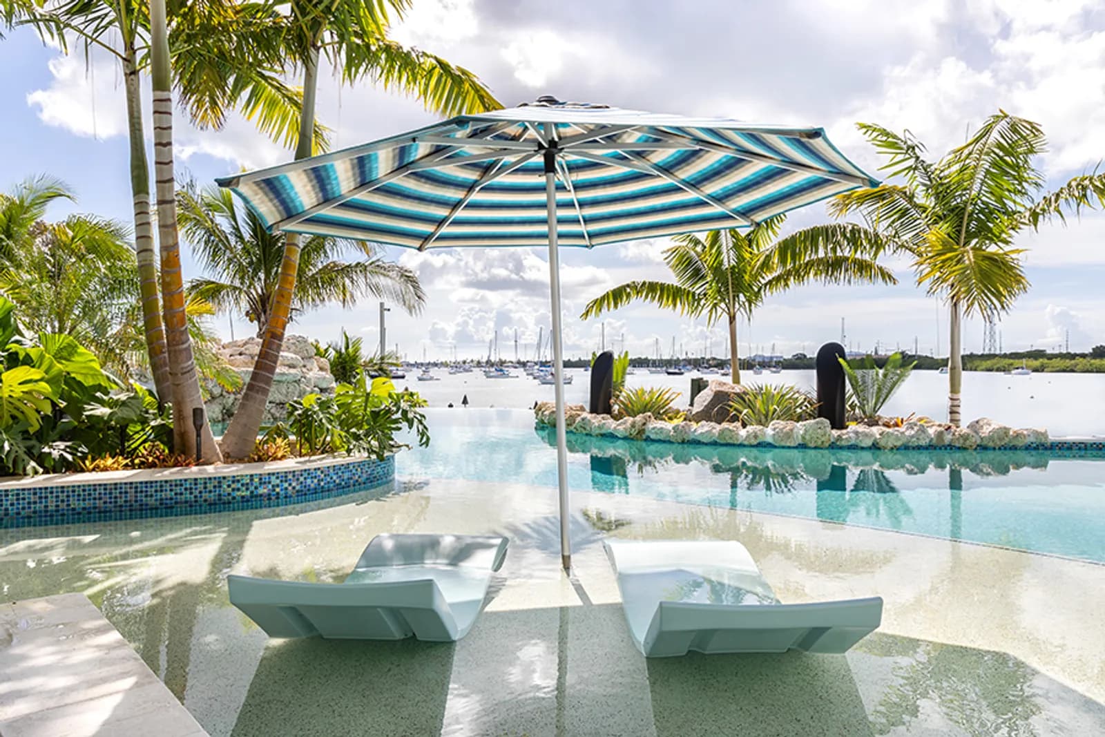 A resort-style pool and marina at the water's edge, day