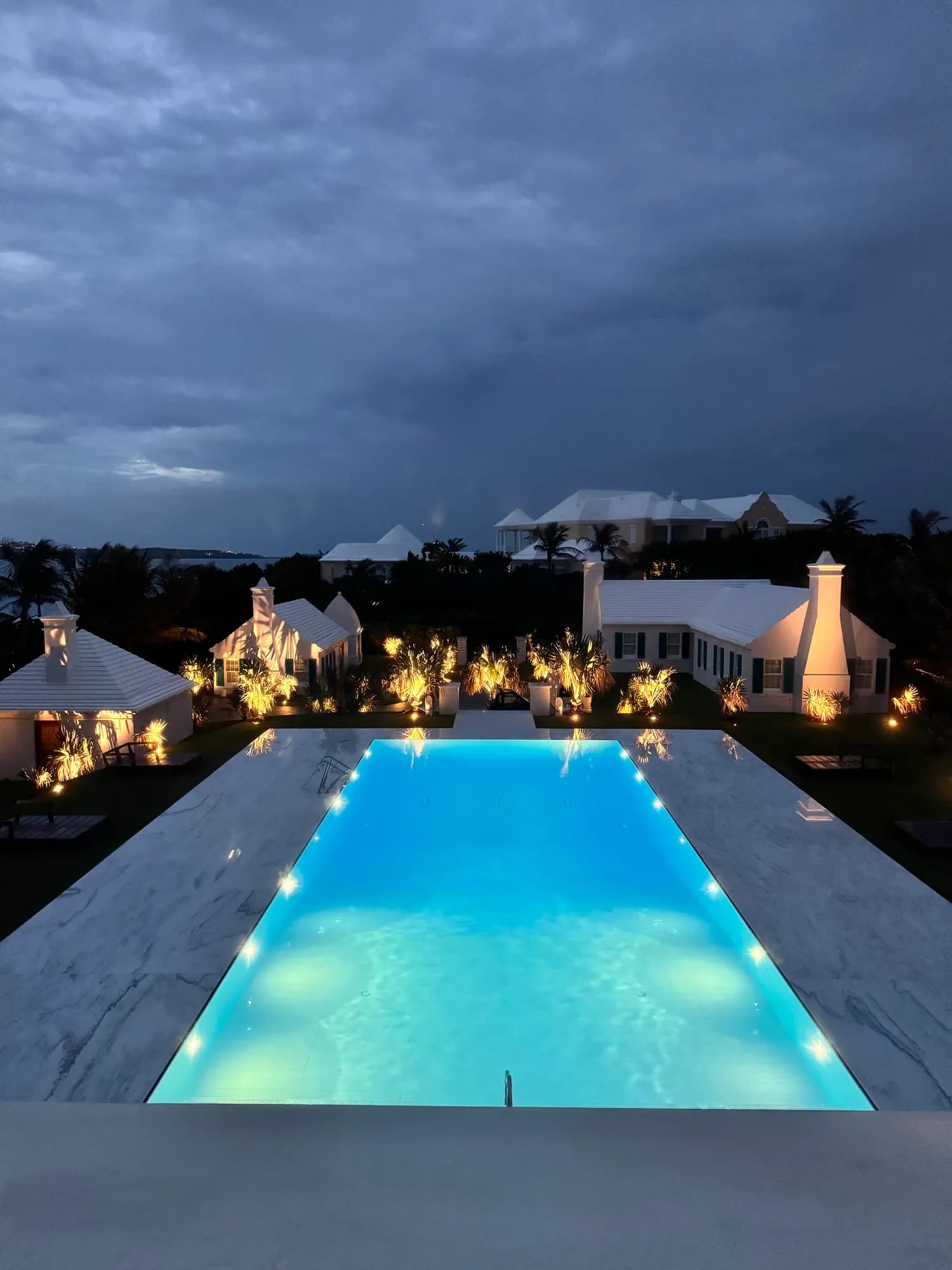 Twilight over the pool and cottages, landscape lighting warm against the blue hour