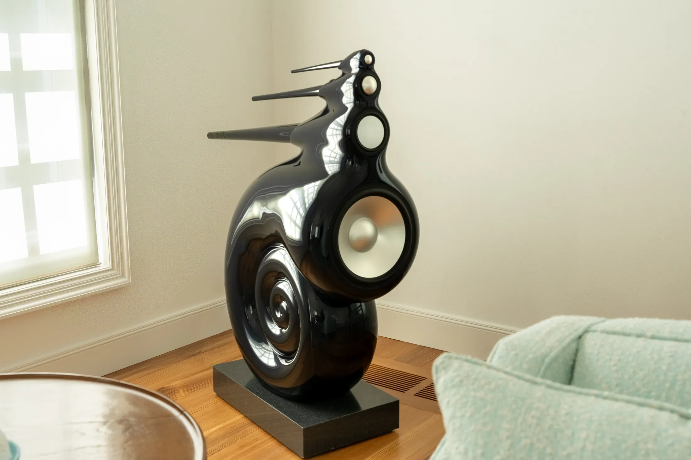A Bowers & Wilkins Nautilus loudspeaker in a warm, light-filled room