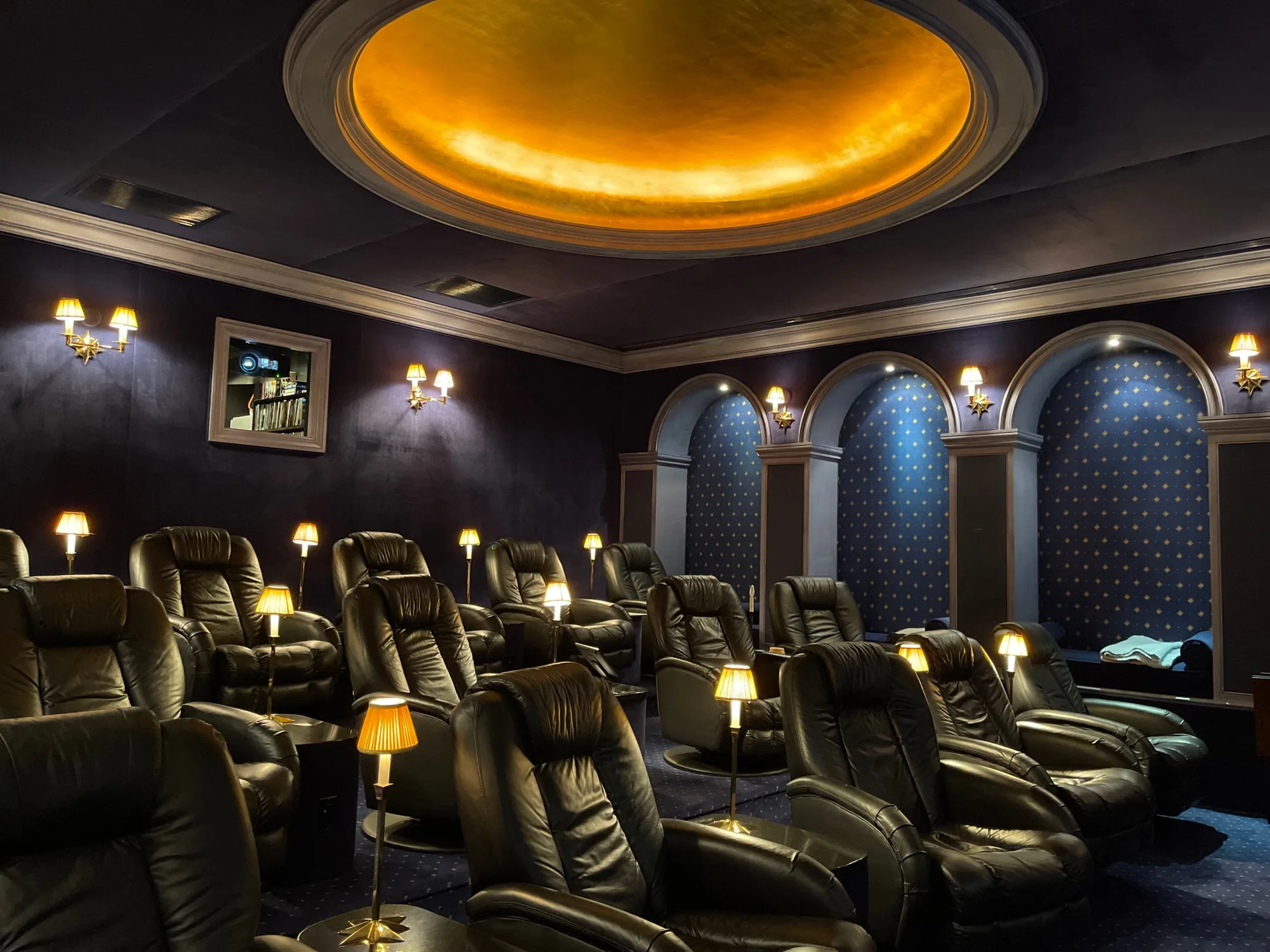 Fifteen leather seats in tiers, each with a small brass lamp, under the gold-leaf dome