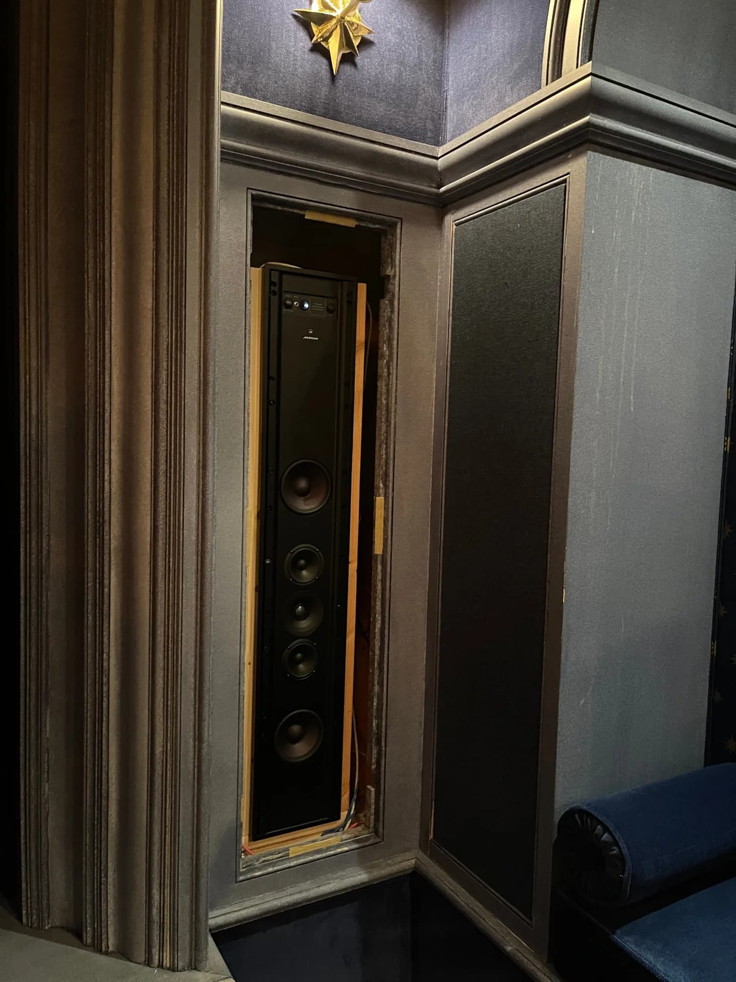A Meridian in-wall loudspeaker, set into the wall before its fabric panel closed over it