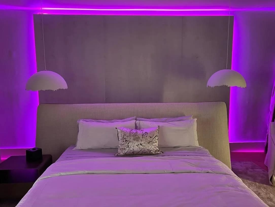 Color cove lighting behind an upholstered headboard