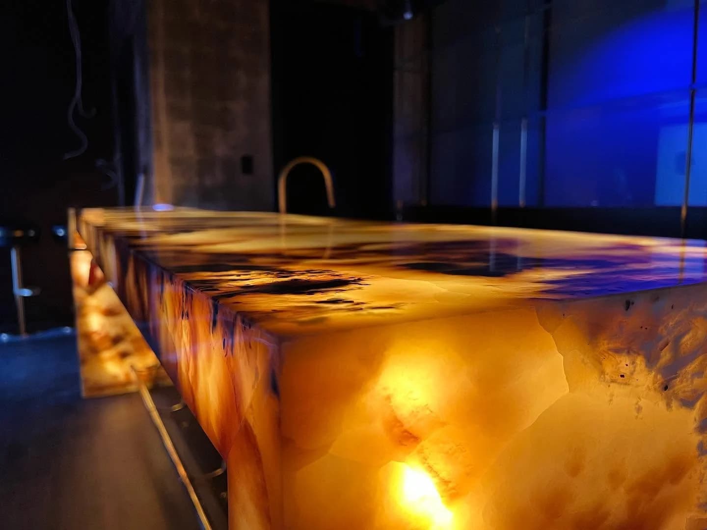 The lit onyx bar top, veining glowing from within