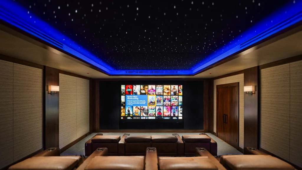 A dedicated home theater with tiered seating and a glowing screen